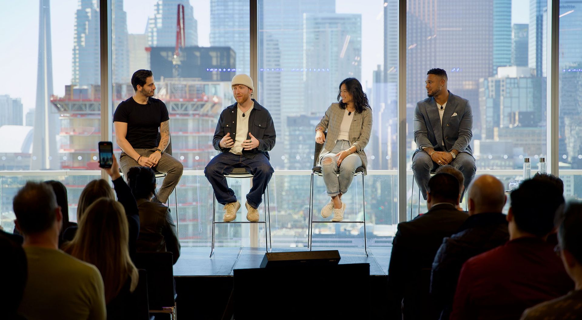 Photo of several guest speakers talking as panellists at a public event.