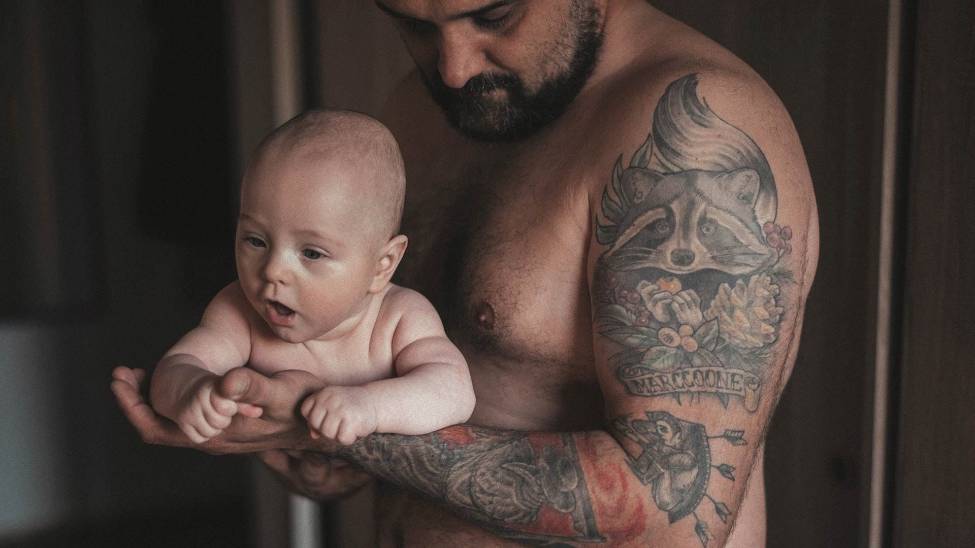 Photo of a father lovingly holding an infant child.