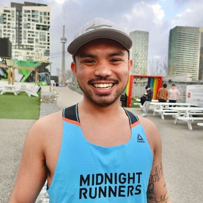 Photo of an athletic man in running attire, smiling to camera.