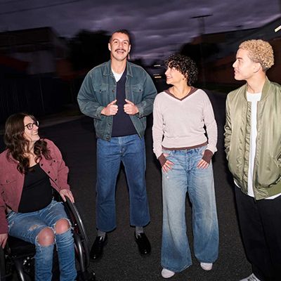 Photo of smiling Movember supporters on a street at night.