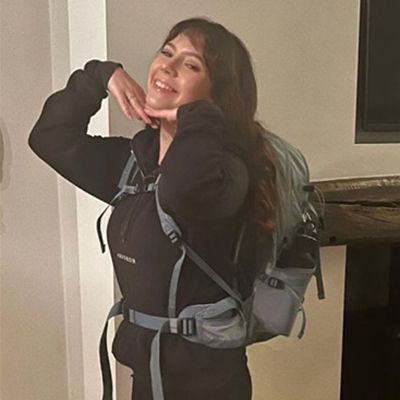 Photo of young woman in hiking gear, smiling to camera.
