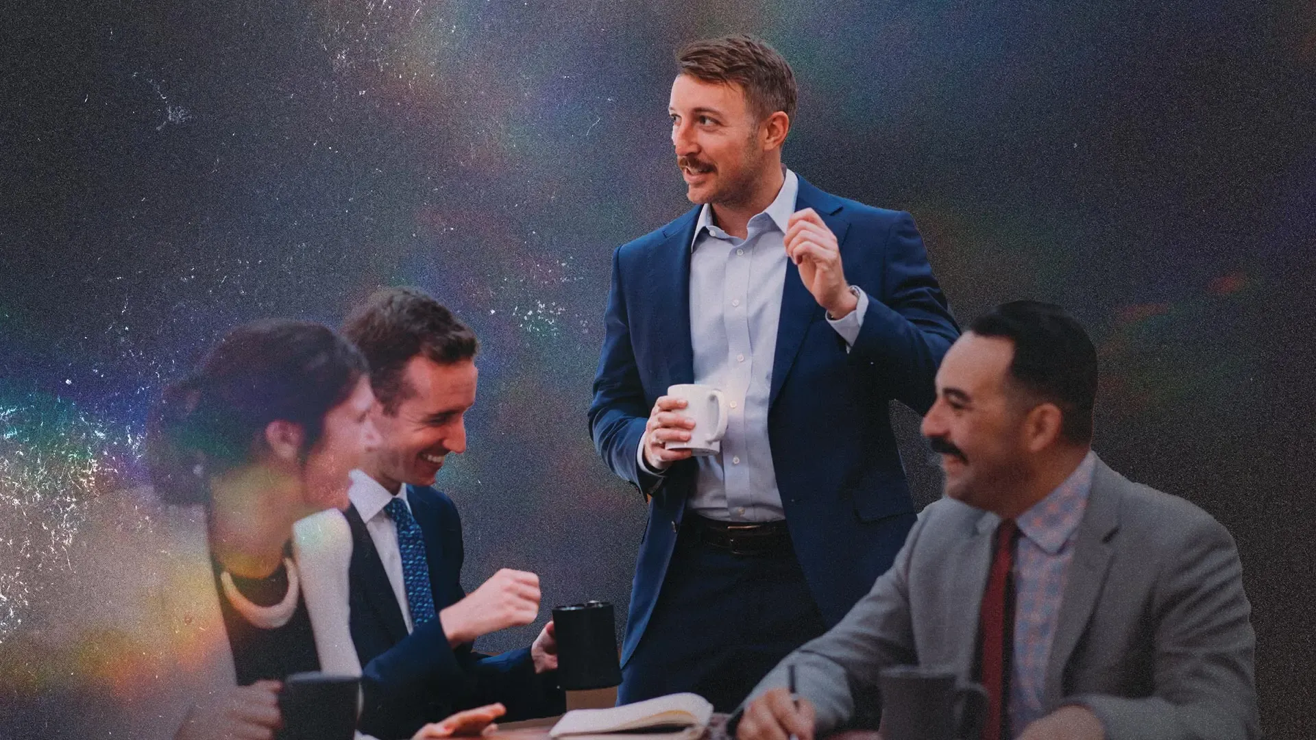 Photo of optimistic-looking people wearing suits in a workplace.